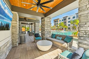 A patio with a white table and blue cushions.